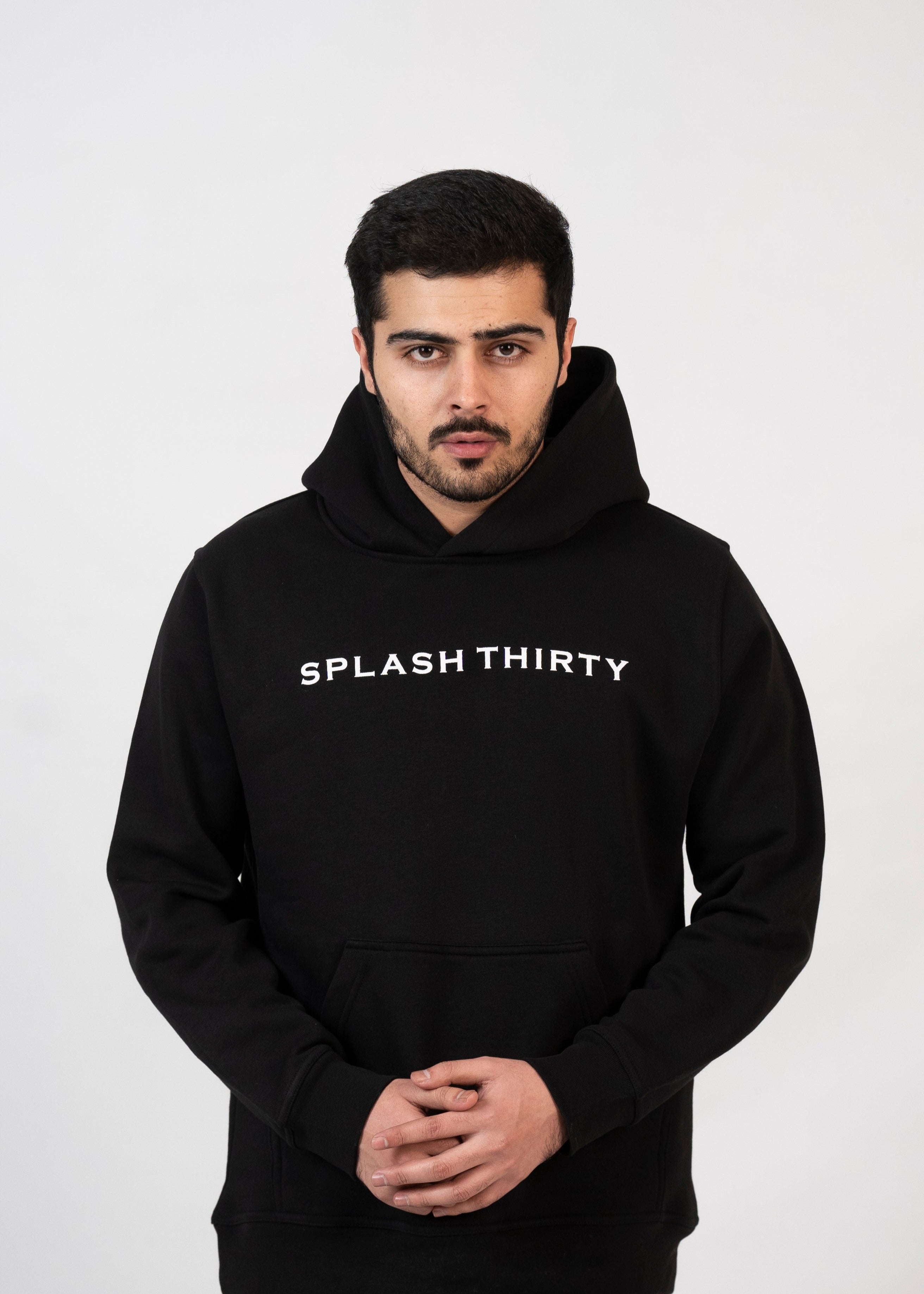 A male model wearing a black hoodie with the text 'Splash Thirty' printed on the front.