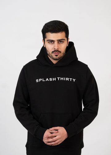 A male model wearing a black hoodie with the text 'Splash Thirty' printed on the front.