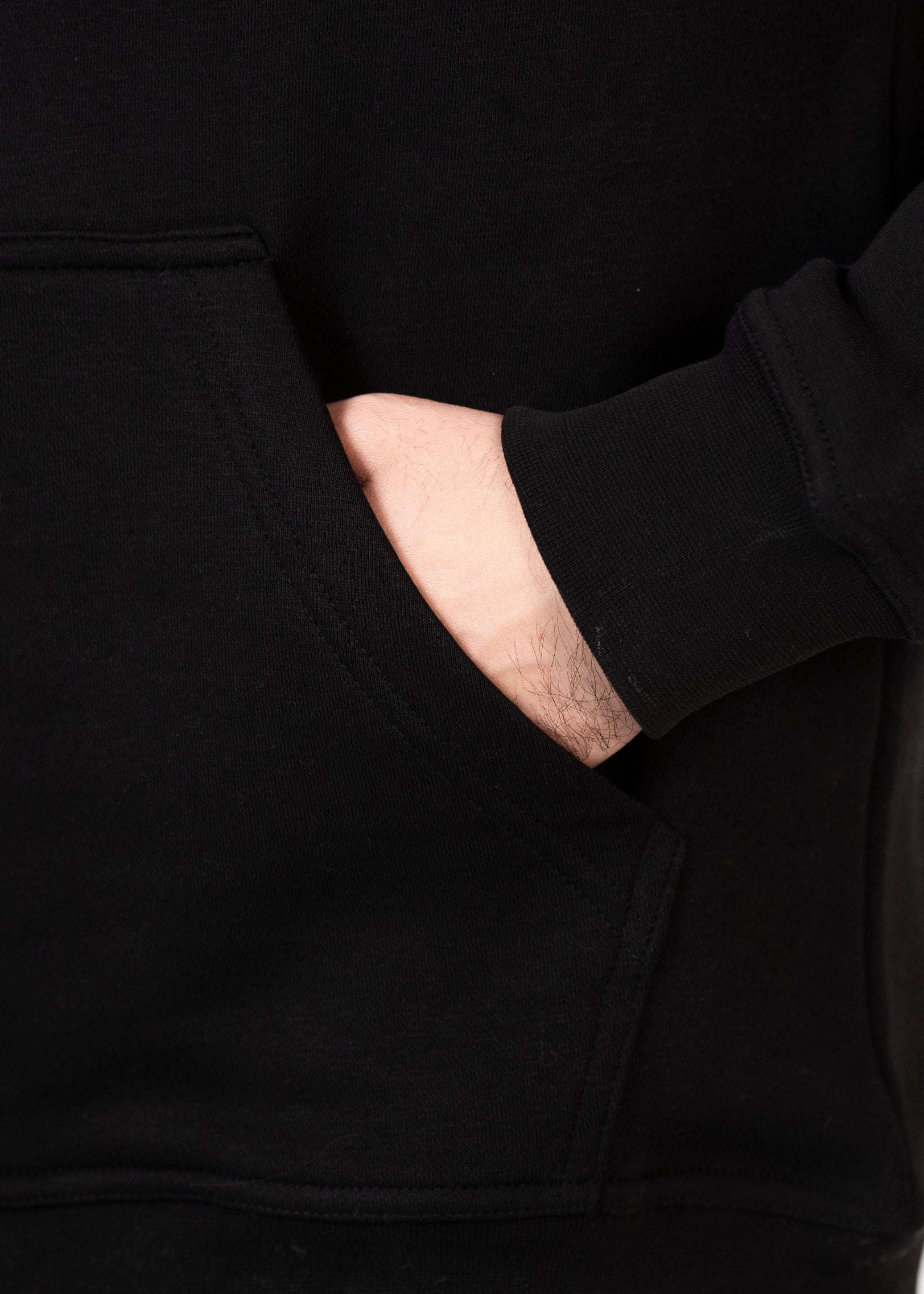 Close-up of a person wearing a black outfit with a pocket detail.