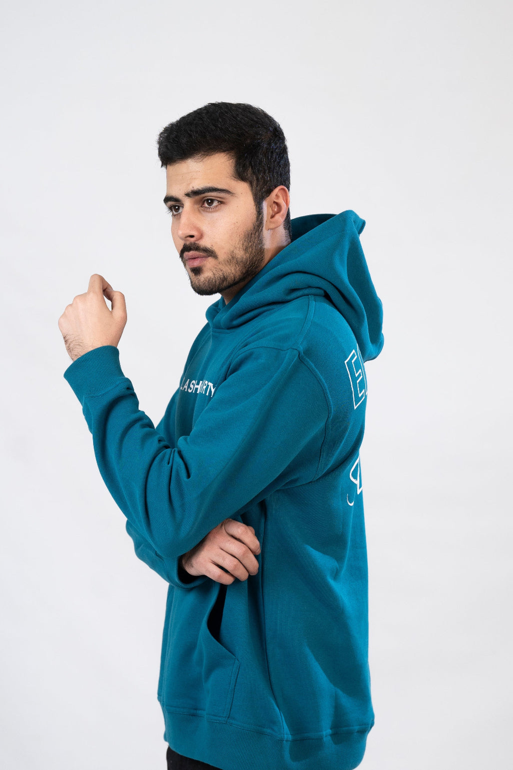 A male model wearing a blue hoodie with a hood, featuring text on the front and back.