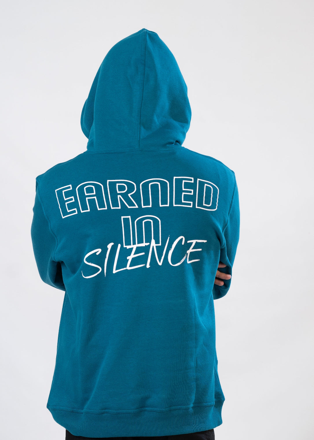 Teal hoodie with 'Earned in Silence' text on the back against a white background
