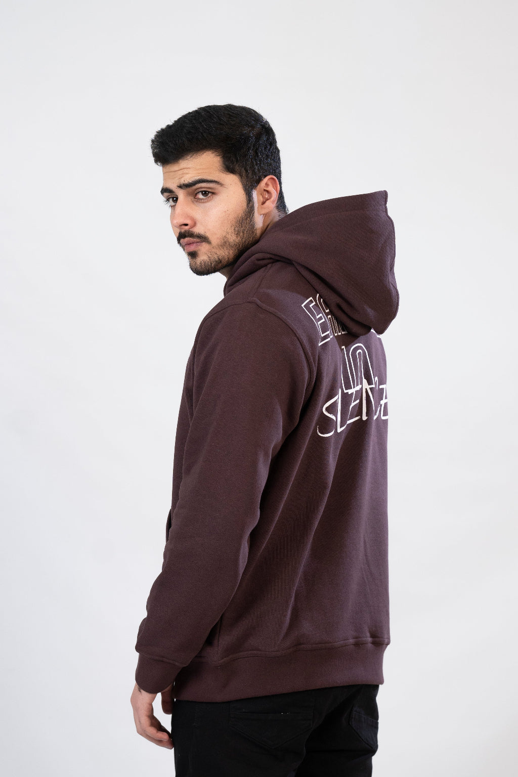 Man wearing a brown hoodie with text on the back against a white background