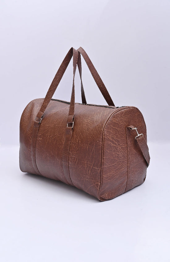 Brown leather duffel bag on a dark background