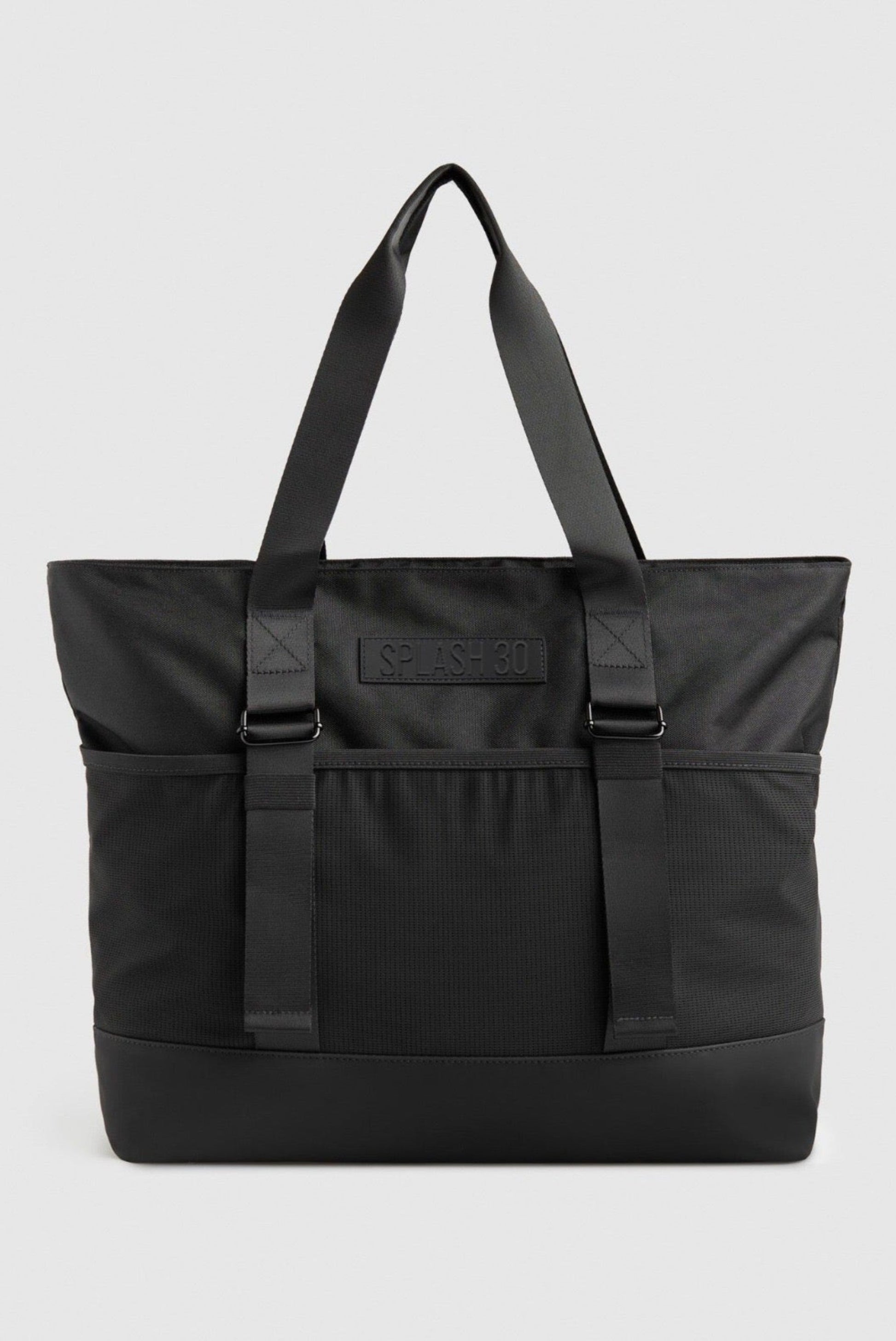 Black tote bag with a visible brand logo on a light gray background.