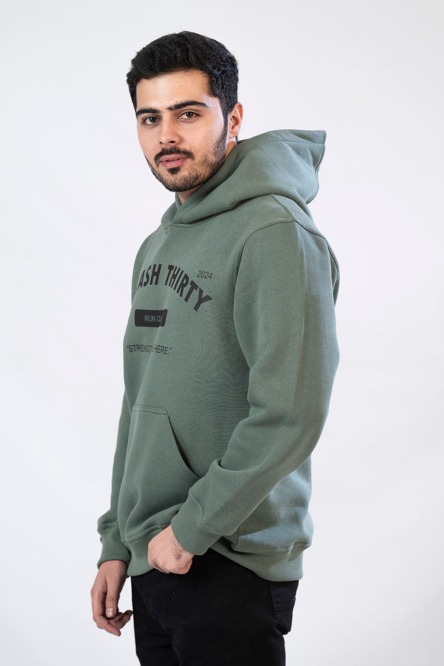 A male model wearing a green hoodie with 'IRON CLUB' text on the front.