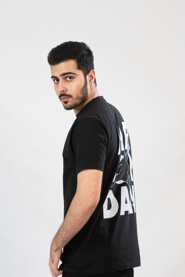 A male model wearing a black t-shirt with 'Air Jordan' text printed on the back.