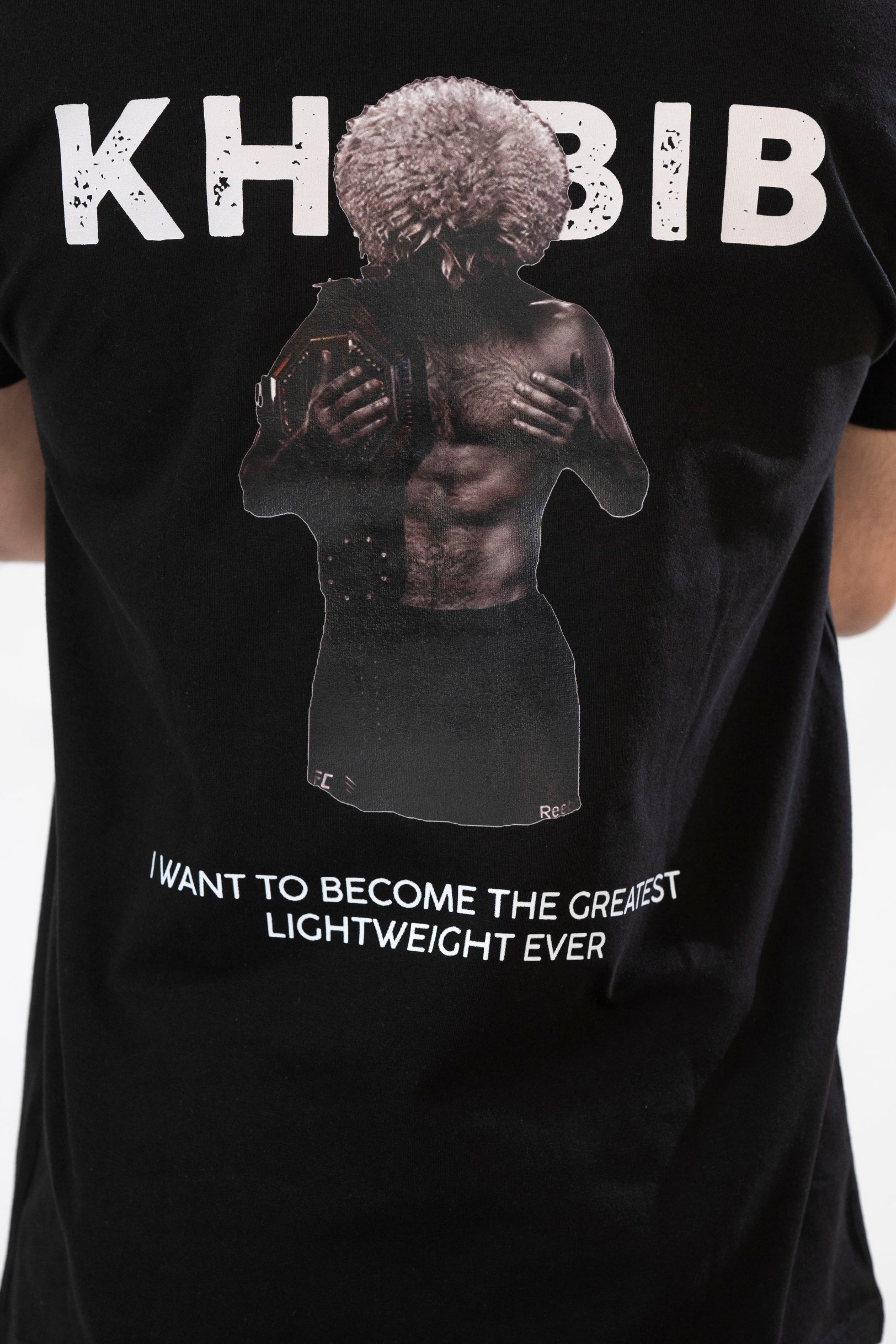 Black t-shirt with graphic of a person hugging themselves and text 'Khabib' and 'I want to become the greatest lightweight ever'.