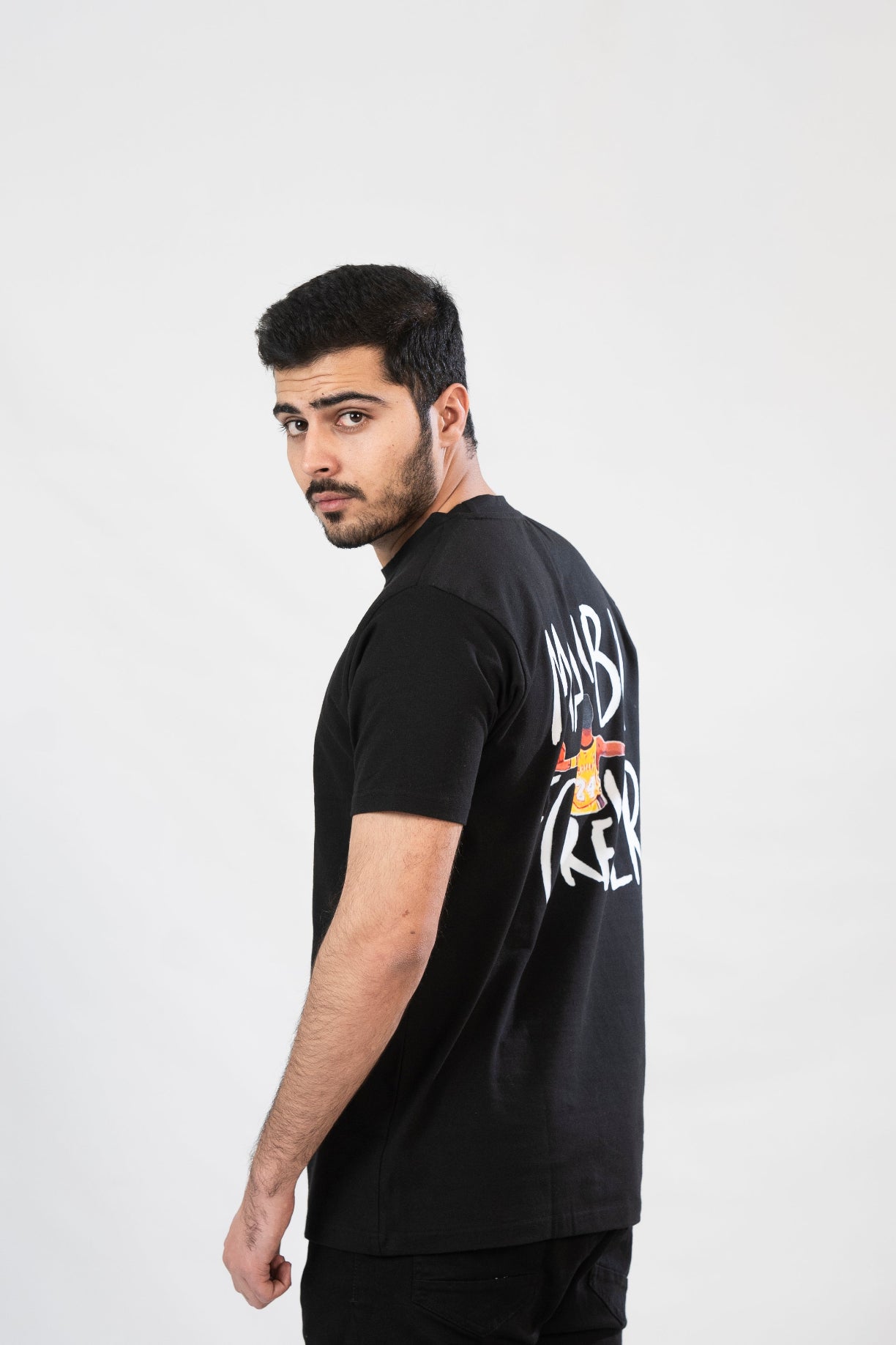 Man wearing a black t-shirt with text on the back against a white background