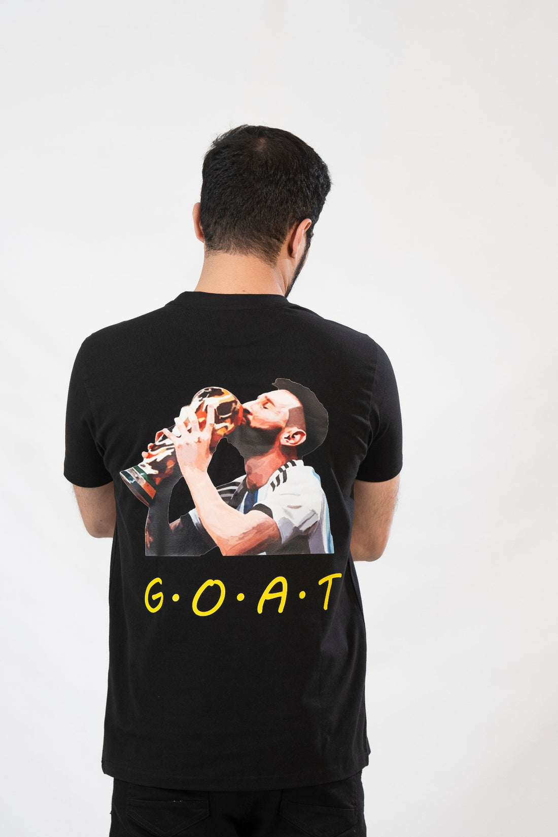 Person wearing a black t-shirt with a graphic and 'G.O.A.T.' text on the back.