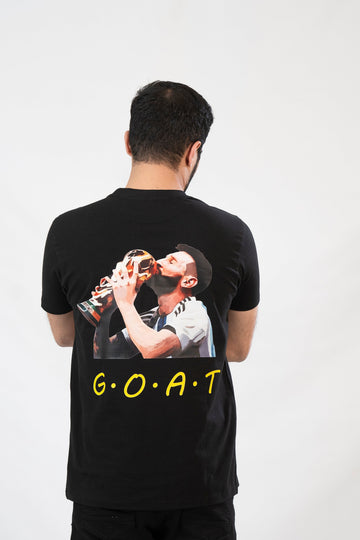 Person wearing a black t-shirt with a graphic and 'G.O.A.T.' text on the back.