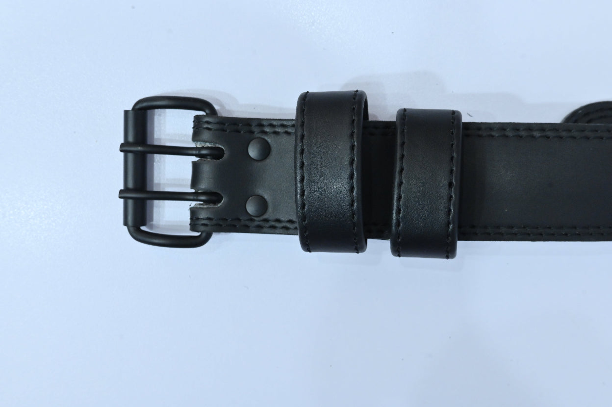 Black leather belt with a buckle on a light gray background