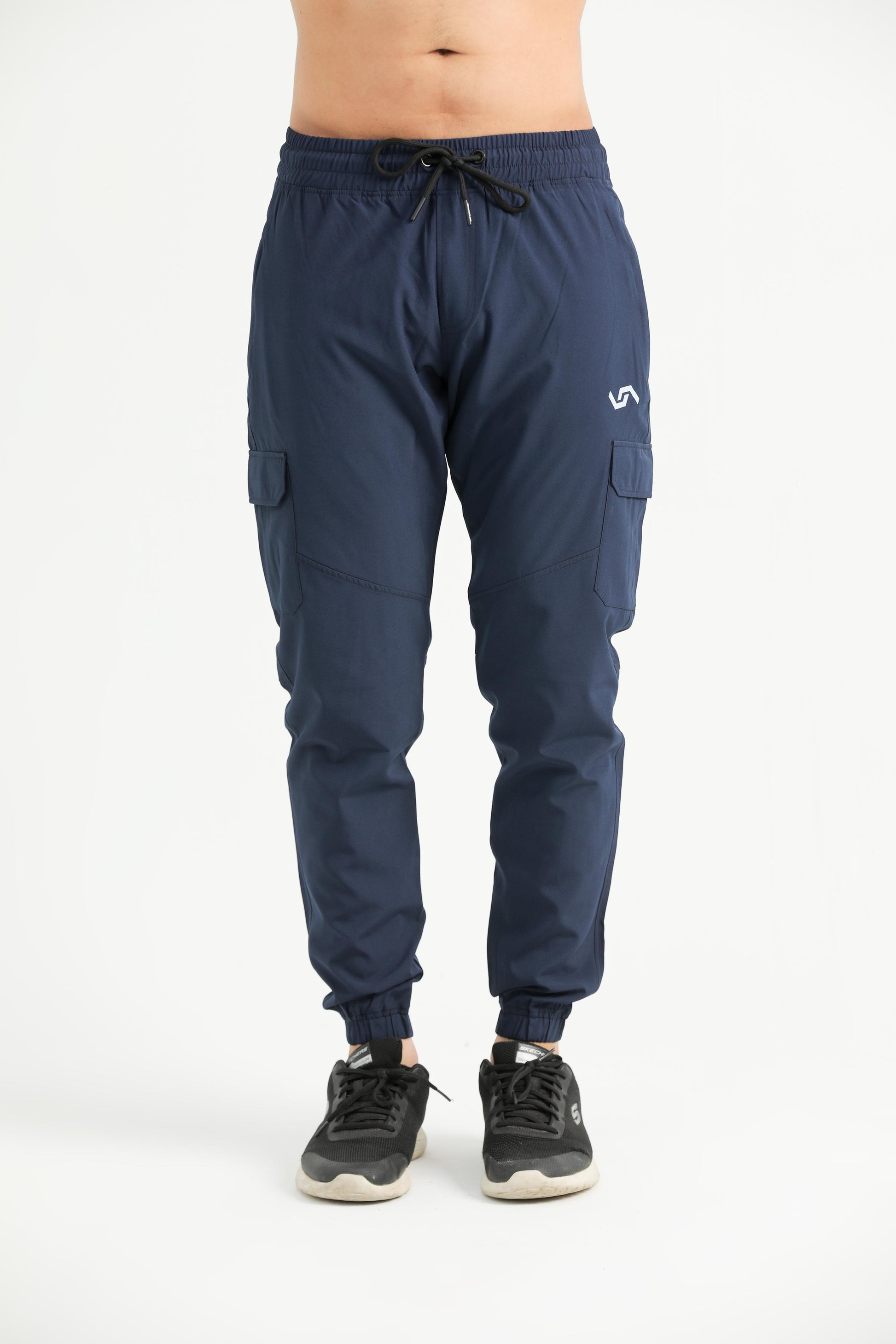 A person standing, wearing navy blue cargo pants with a drawstring waist and elastic bottom cuffs, paired with a white top and black sneakers.