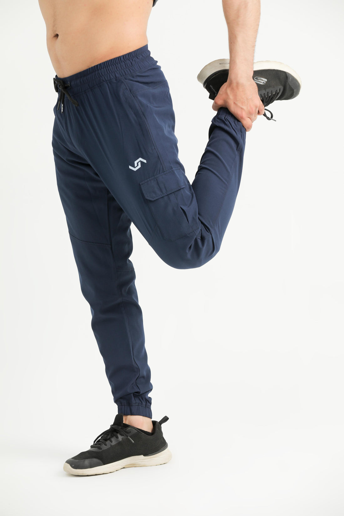 A person standing, wearing navy blue cargo pants with a drawstring waist and elastic bottom cuffs, paired with a white top and black sneakers.