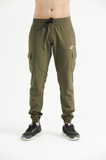 A person standing wearing green cargo pants with elastic bottom cuffs and multiple pockets, paired with a white top and black shoes.