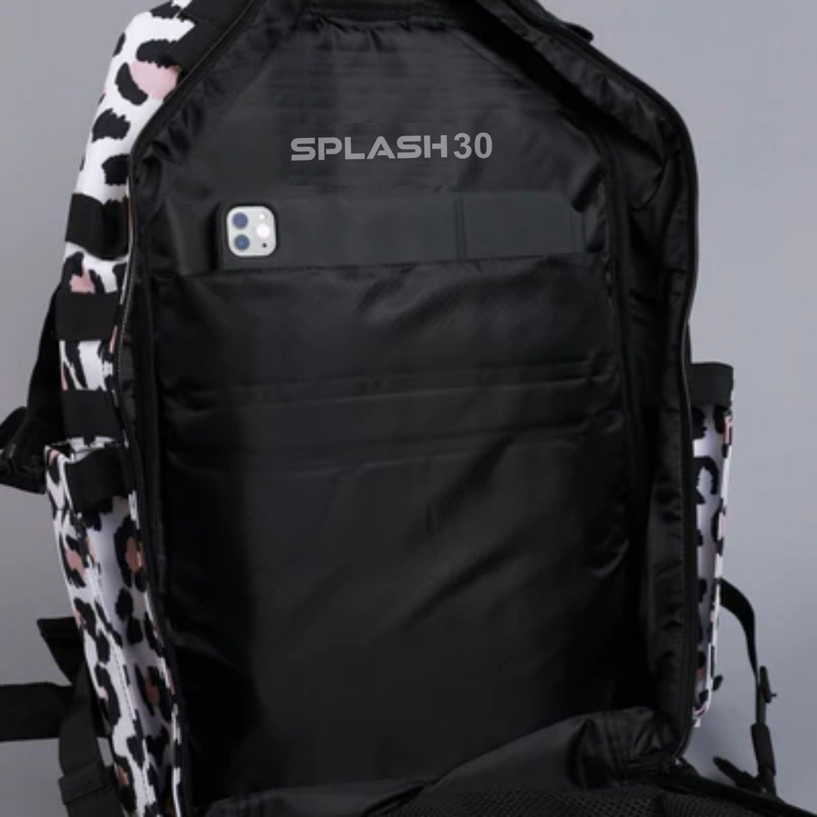 Black backpack with 'SPLASH30' branding and a phone pocket on a gray background