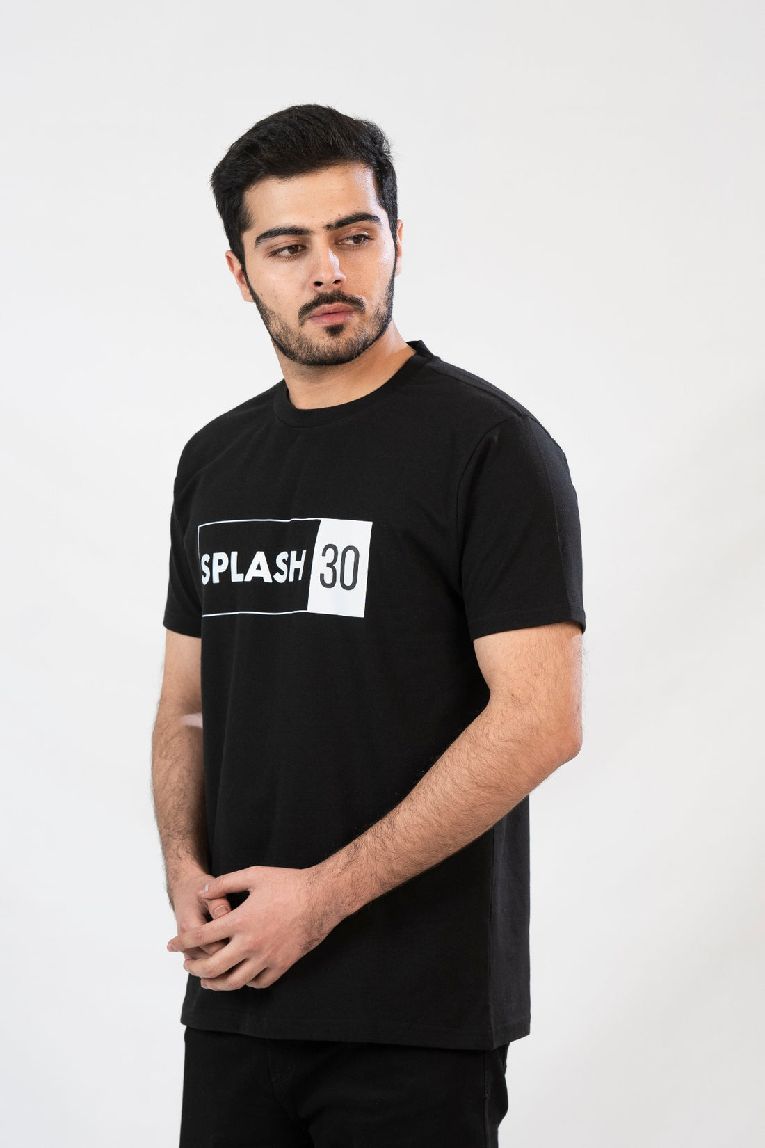 A man standing, wearing a black T-shirt with the text 'Splash 90' printed on the front.