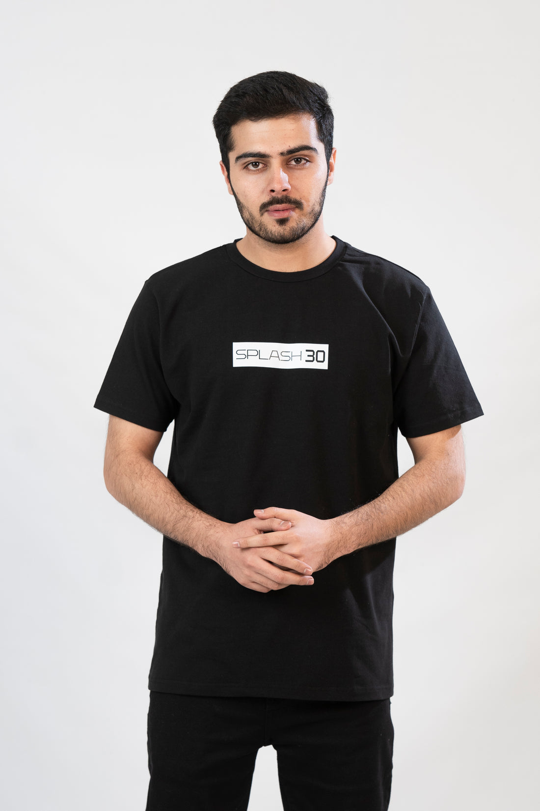A man standing, wearing a black T-shirt with 'Splash Vibe' text on the front.