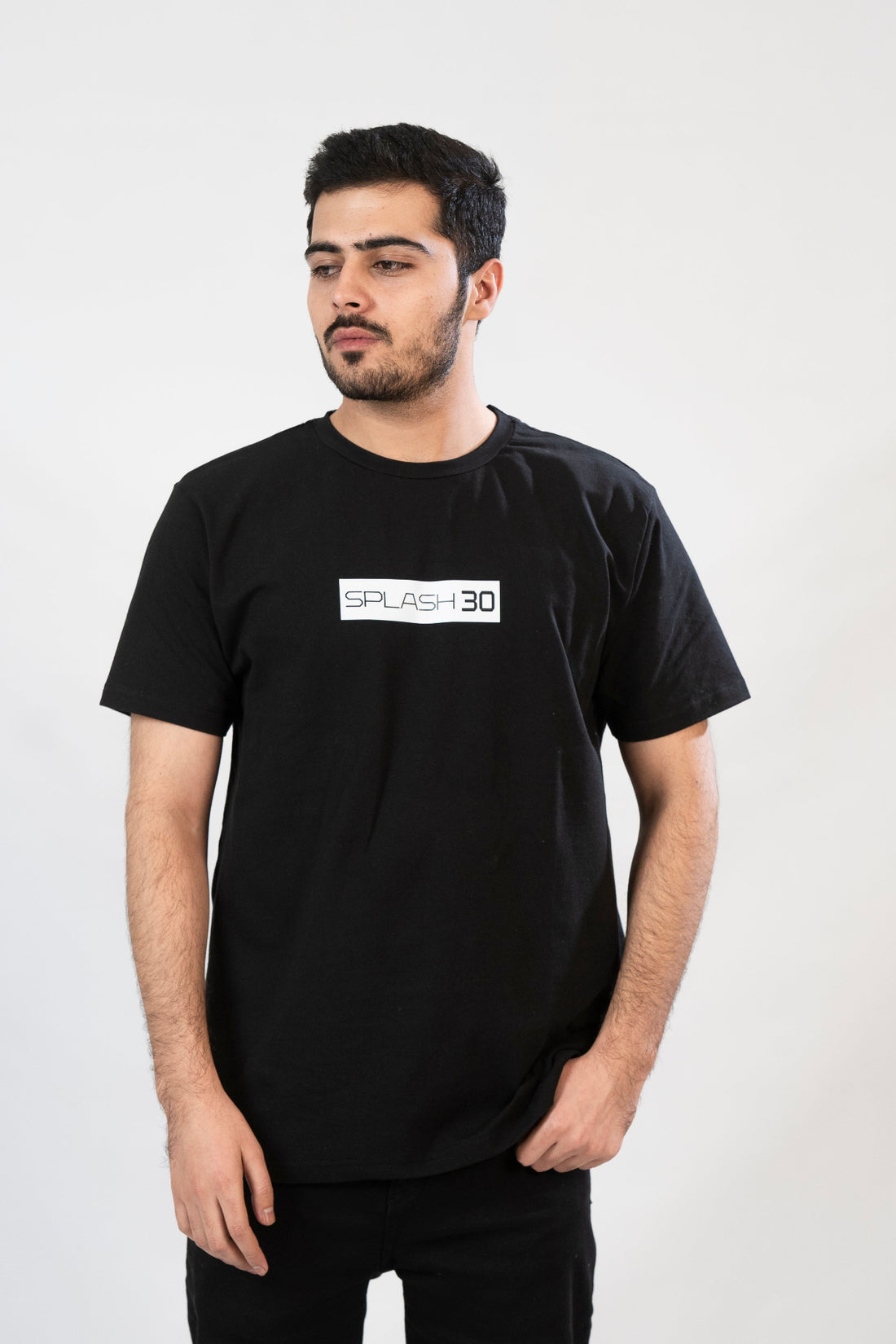 A man standing, wearing a black T-shirt with 'Splash Vibe' text on the front.