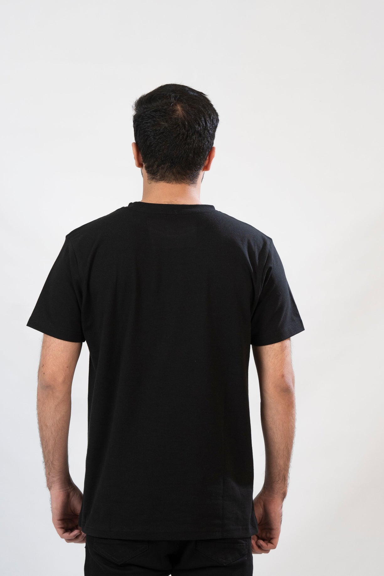 Person wearing a black t-shirt against a white background
