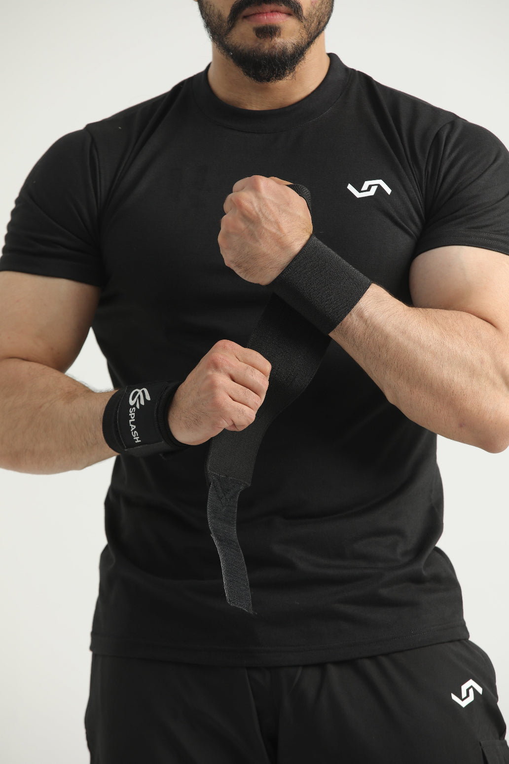 A pair of black wrist wraps with the 'Slash' brand logo on the strap.