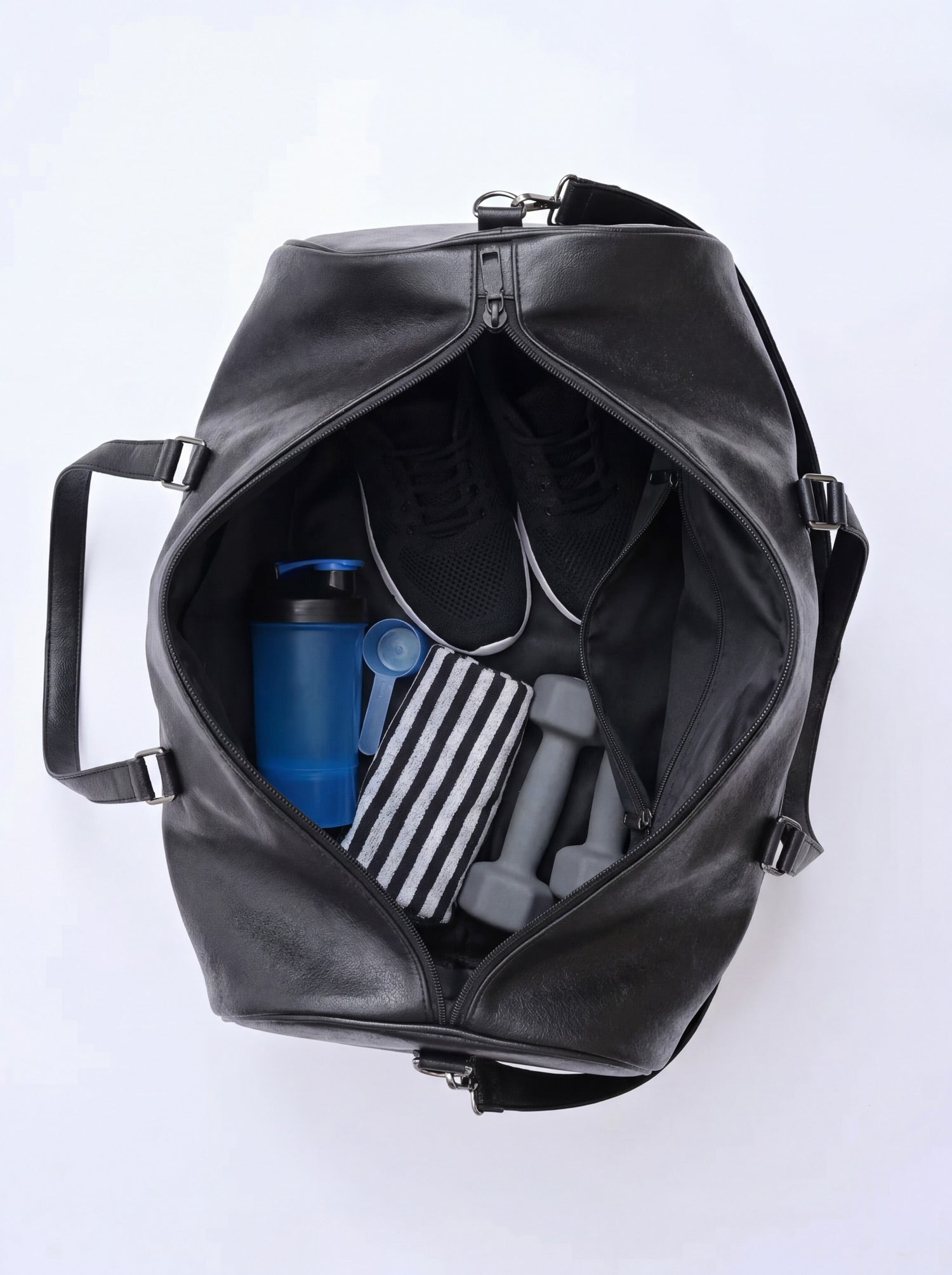 Splash30 Black Leather Duffle Bag 40L open interior packed with gym bottle, resistance bands and shoes showing capacity