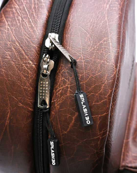 Close-up of Splash30 branded label and zipper on brown PU leather backpack