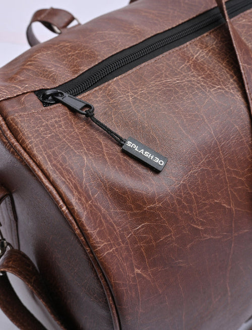 Close-up of Splash30 branded zipper pull on brown PU leather duffle bag showing leather texture and stitching