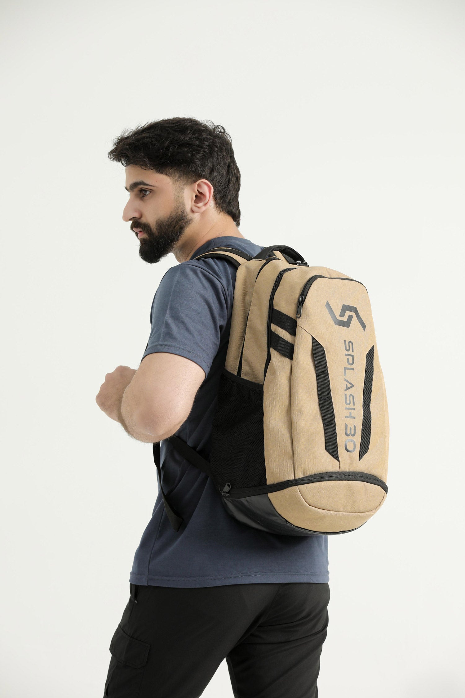 Model wearing the beige Splash 30 Everyday backpack over the shoulder, side view