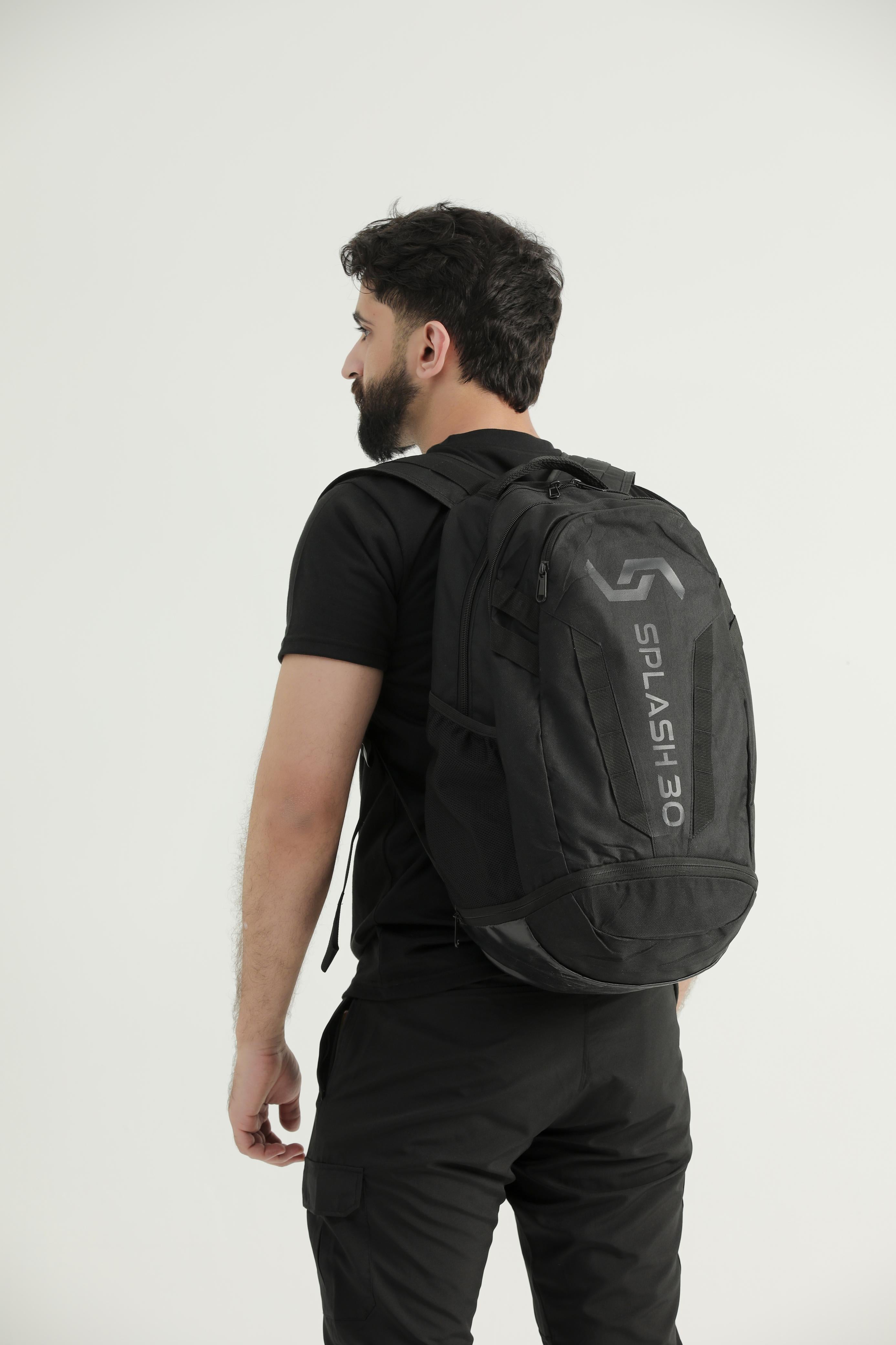 Model wearing the black Splash 30 Everyday backpack over the shoulder, side view showing the bottle pocket and Splash logo