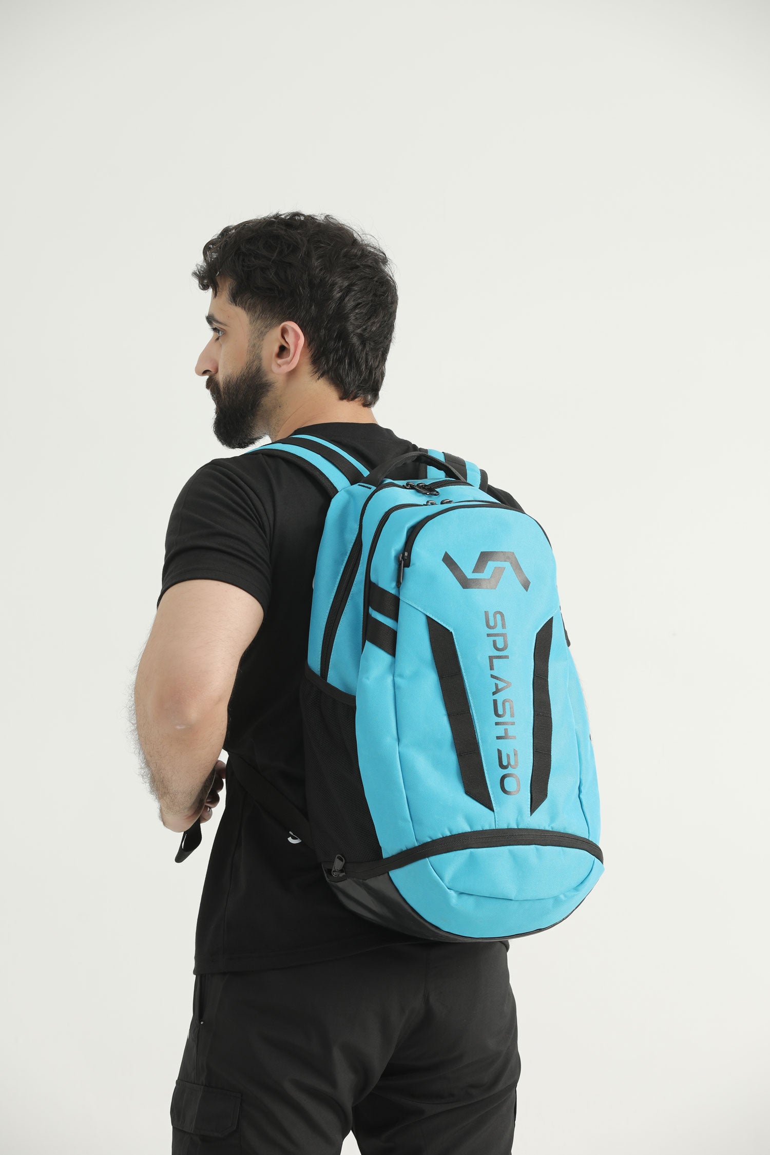 Model wearing the blue Splash 30 Everyday backpack, back view showing padded straps and the Splash logo