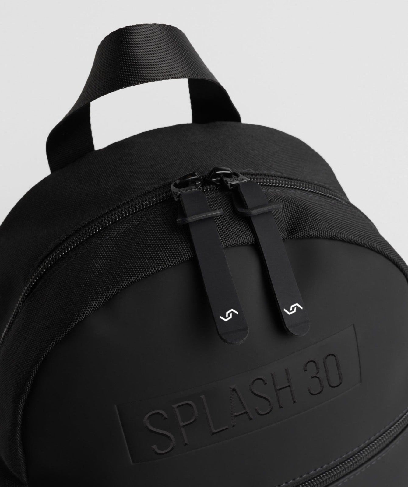 Close-up of Splash30 embossed branding on black everyday mini backpack 8L