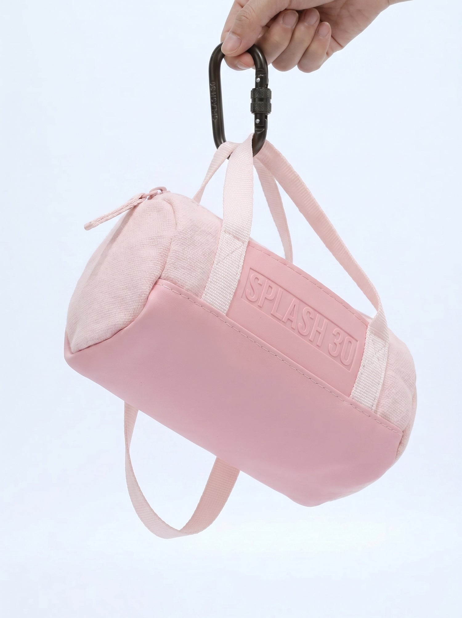 Hand holding Splash30 Mini Holdall Keychain pink showing scale and size
