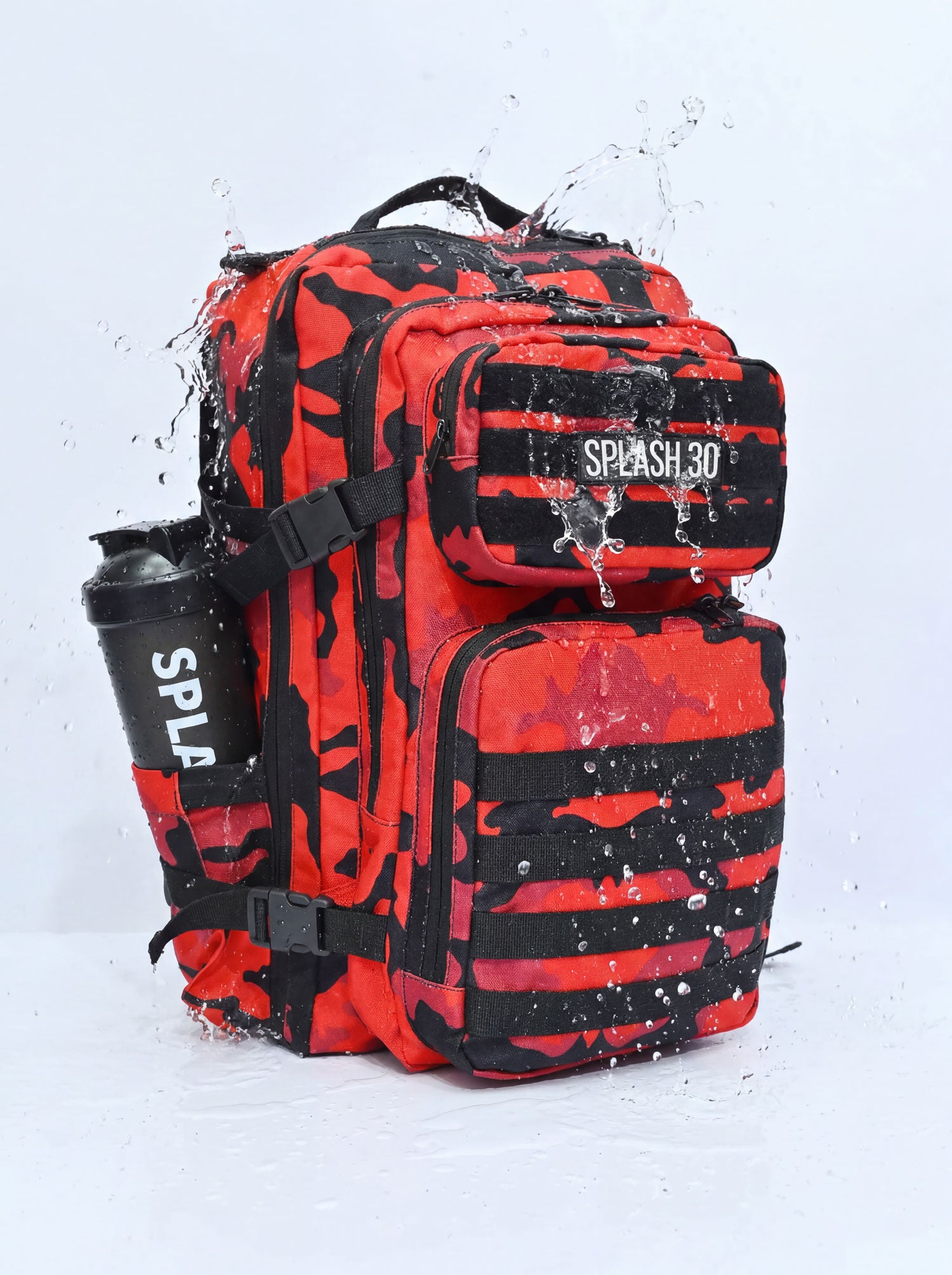 Splash30 Premium Red Camo Backpack 45L water resistant test with heavy water splash showing Oxford 900D waterproof construction and Splash30 shaker bottle in side pocket